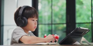亚洲小男孩组装分子模型在家学习与学校老师在线教学。在家教育的孩子通过远程应用与老师练习思考逻辑和会议。