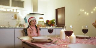 快乐的家庭时间和关系，亚洲大家庭有一个小的圣诞聚会，在家里一起吃食物。孩子很高兴看到父母、表兄准备食物并带到家里的餐桌上。