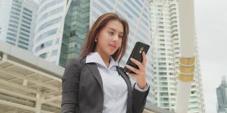 亚洲失业妇女感到高兴后，她看智能手机知道结果，她已经通过了面试的业务办公室在大公司。
