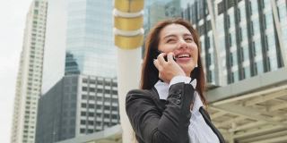 亚洲年轻精明的女商人在城市里打电话。以电信和移动网络为经营理念。