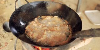 炸猪肉在金属锅和热油特写。对泰国人来说是非常美味的食物和小吃。