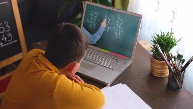 6-7岁可爱的孩子从电脑学习数学。学习在家里。在线教育