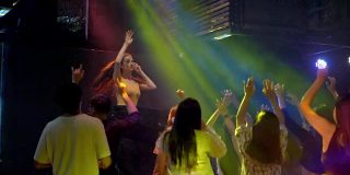 女DJ在灯光效果的音乐会晚会上跳舞。年轻人在俱乐部跳舞。夜生活派对和迪斯科概念与灯光效果。