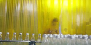 亚洲男主管在饮料加工厂检查药草饮料生产线。女工检查瓶中饮料产品流水线加工厂工业理念