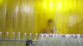 亚洲男主管在饮料加工厂检查药草饮料生产线。女工检查瓶中饮料产品流水线加工厂工业理念视频素材模板下载
