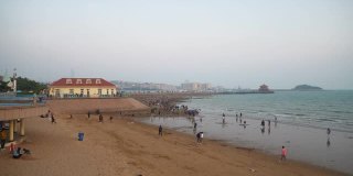 日落天空青岛海岸线著名的拥挤公共海滩全景4k中国