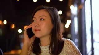 一个快乐的年轻亚洲女人在咖啡馆里打电话视频素材模板下载
