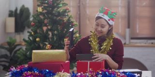 年轻的亚洲少女打开圣诞礼盒
