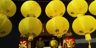 传统的黄色灯笼挂在中国寺庙的门前。