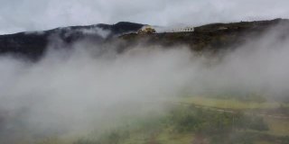 云层之上，一座藏传佛教寺庙耸立在群山之中