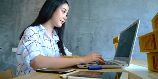 年轻的亚洲人在家用笔记本电脑在网上购物。在线销售和配送理念