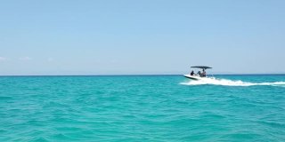 在希腊的哈尔基迪基地区，快艇在夏天的海面上行驶，蔚蓝的天空，蔚蓝的大海，