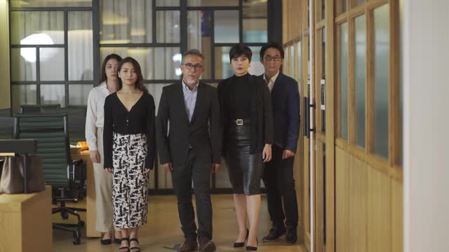 亚洲华人成功的办公室管理团队走向镜头冷静的态度