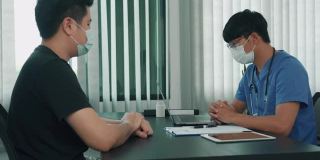 在疫情期间，医生们戴着口罩向患者解释治疗方法。