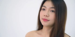 年轻的亚洲20多岁的女人黑色光滑的头发化妆品化妆漂亮的脸看起来在白色的背景上表达情感，病毒剪辑或广告