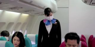 空中小姐指示乘客在飞机上戴口罩。