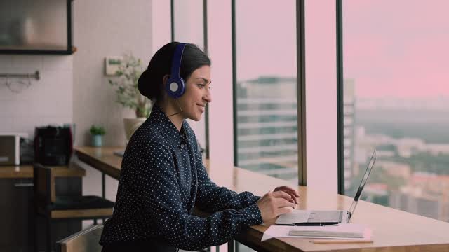 印度女商人戴着耳机用笔记本电脑通过视频电话会议进行交流