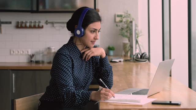 印度女子学英语戴耳机听音频课程