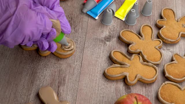 用你的双手制作传统的圣诞姜饼人。烹饪姜饼，用糖粉填充。假期将手工制作的。烹饪，涂上釉料