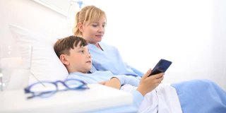护士在医院里用躺在床上的手机自拍照顾一个孩子
