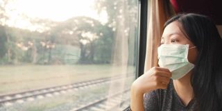 亚洲女性戴口罩乘坐火车小心乘坐公共交通工具。4 k慢动作。