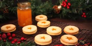 女人把手放在一个传统奥地利圣诞饼干林泽饼干充满杏子果酱烤架上。