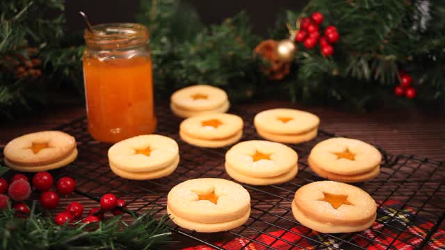 女子手拿一份奥地利传统圣诞饼干林泽饼干，里面填充了杏子果酱。