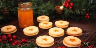 女子手拿一份奥地利传统圣诞饼干林泽饼干，里面填充了杏子果酱。