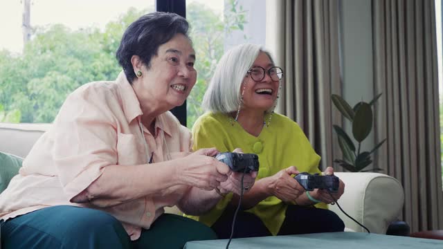 亚洲资深女性朋友喜欢在家里的客厅里一起玩电子游戏