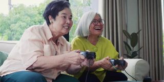 亚洲资深女性朋友喜欢在家里的客厅里一起玩电子游戏