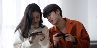 年轻的亚洲夫妇在玩手机