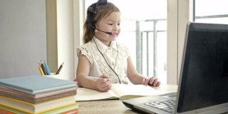 小女孩通过互联网与老师交流。隔离期间的在线培训