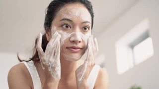 美丽的亚洲女性用水洗脸洗脸。视频素材模板下载