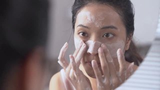 美丽的亚洲女性用水洗脸洗脸。视频素材模板下载
