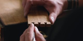 木工用木凿把燕尾榫刻进橡木板里。木工工艺,手工艺品。木工工具的声音