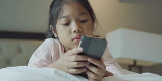小女孩在卧室里使用科技社交媒体。