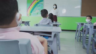 小学生在教室里戴着口罩。视频素材模板下载