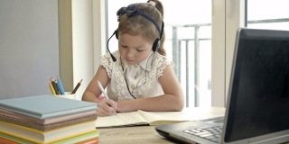小女孩通过互联网与老师交流。隔离期间的在线培训