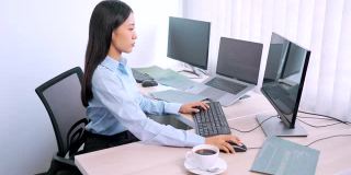 亚洲女程序员，在办公室用电脑输入源代码来开发程序或应用程序