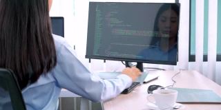亚洲女程序员，在办公室用电脑输入源代码来开发程序或应用程序