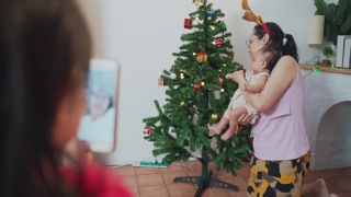 可爱的小女孩在圣诞节期间用手机视频打电话给奶奶视频素材模板下载