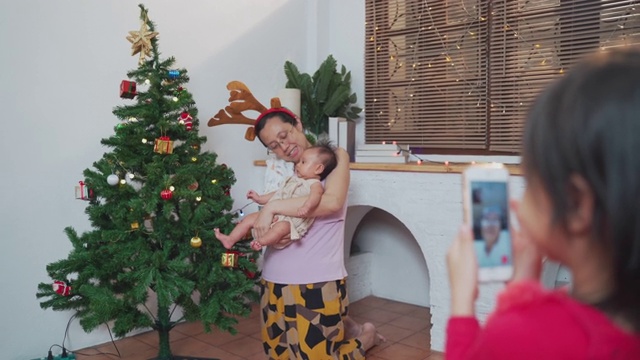 可爱的小女孩在圣诞节期间用手机视频打电话给奶奶
