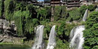 鸟瞰图美丽的芙蓉瀑布在著名的古镇。令人惊叹的亚洲老城鸟瞰图和瀑布。中国湖南湘西芙蓉高质量的免版税库存素材。