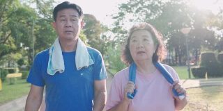 亚洲老夫妇在休闲公园里散步，健康的退休生活方式