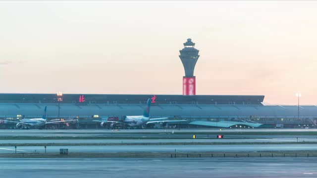 间隔拍摄。北京首都国际机场日落航站楼，飞机起飞。(汉字的意思是“北京”)