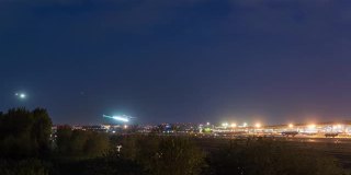 间隔拍摄。北京首都国际机场夜间航站楼，飞机降落，中国。