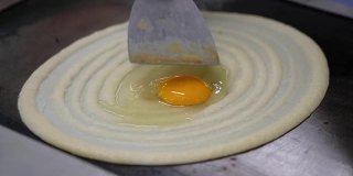 制作泰国煎饼夹鸡蛋的特写，泰国甜品街头小吃
