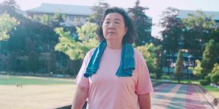 亚洲老年女性在阳光明媚的日子里在公园的跑道上散步，减肥控制肥胖，放松锻炼，退休生活积极活动