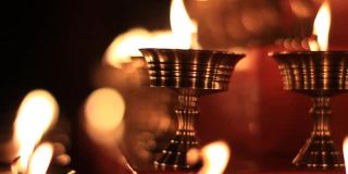 寺庙牛油灯节上的佛坛蜡烛视频。在金属容器中祈祷的油灯和摇曳的火焰，宁静的风景
