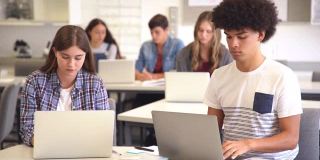 学生在大学上电脑课时使用笔记本电脑